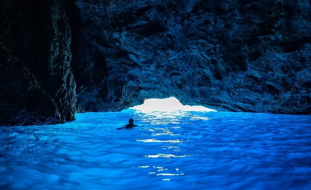 Sunlight turning the water electric blue inside the Blue Cave on Koločep